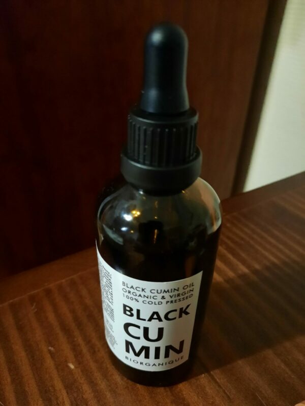 Bottle of black cumin oil for beard (back view)