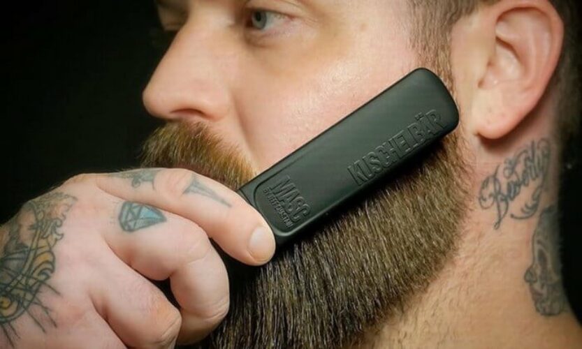 Bearded man smoothing comb