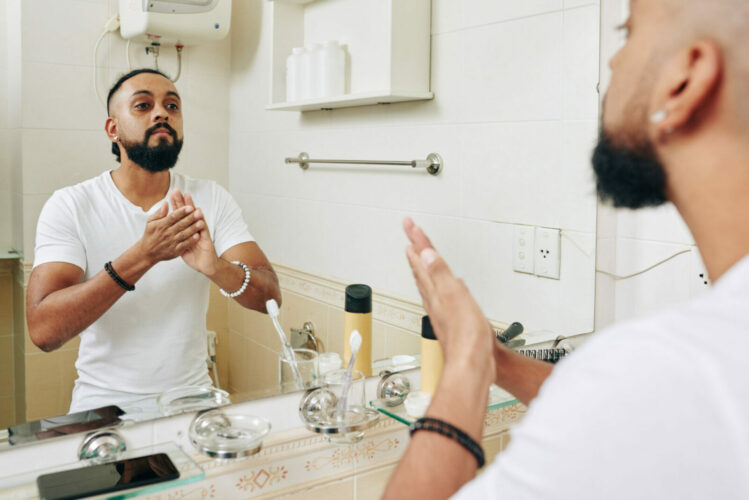 Un hombre se aplica aceite para la barba