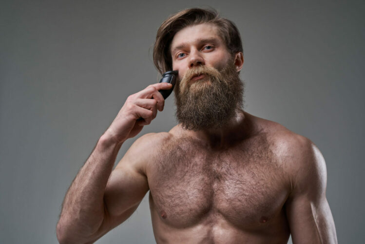 Hombre sosteniendo una recortadora de barba
