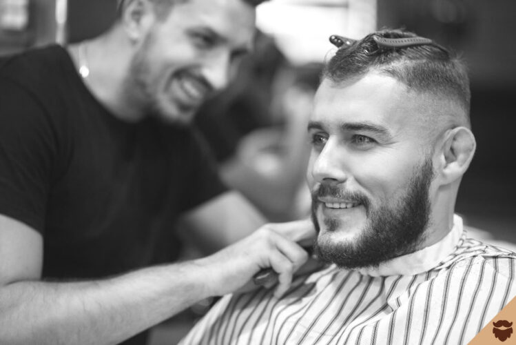 Young man shaves his beard at the barber shop
