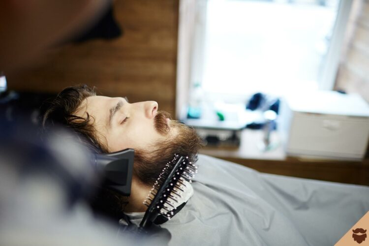 Homme se fait un brushing de barbe avec seche cheveux