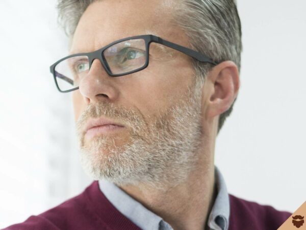 Hombre de 50 años con barba corta y gris y gafas